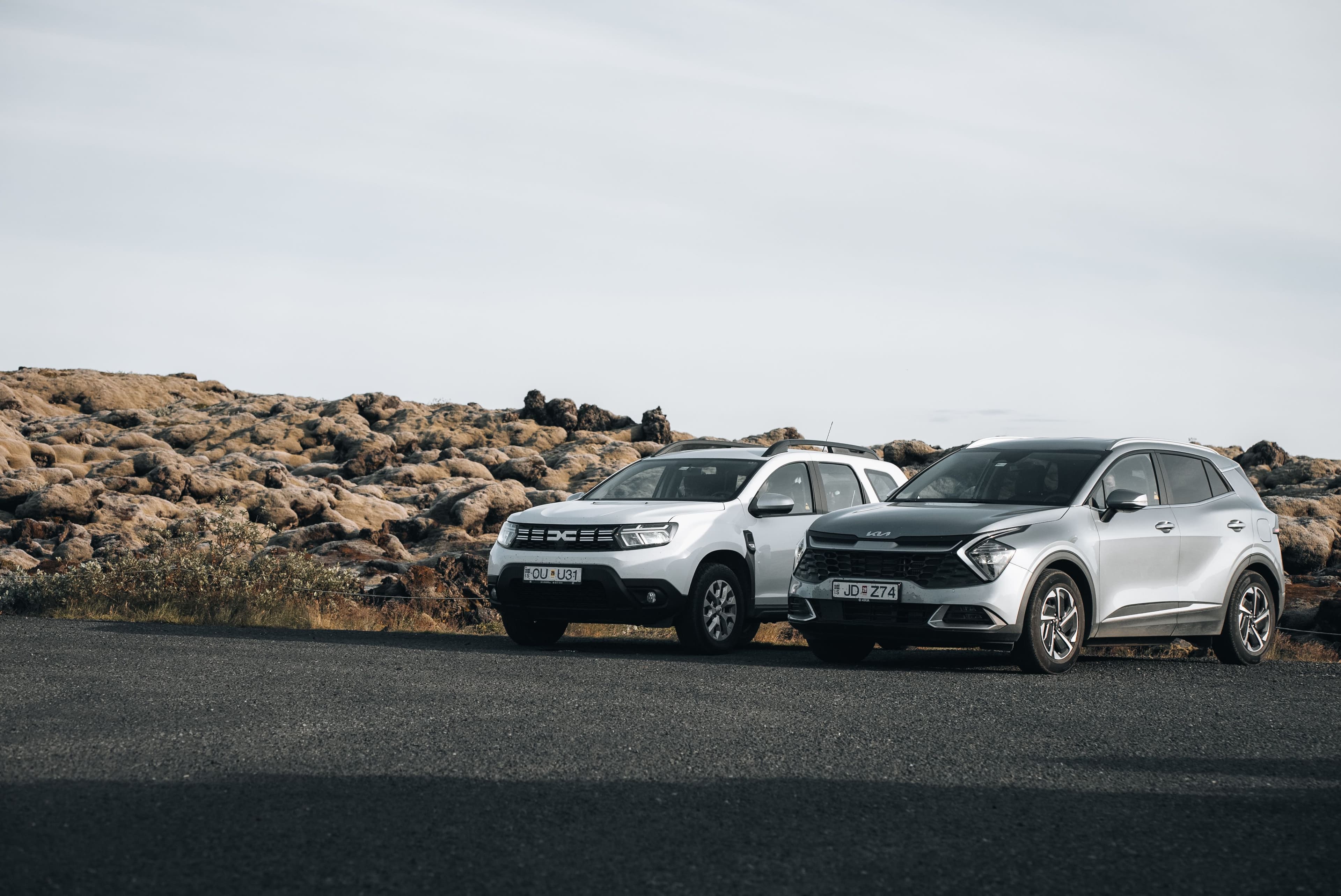 Two medium sized 4x4 rental cars parked on the side of the road in Iceland